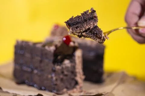Hand taking a small portion of chocolate cake from slice Stockfoto's