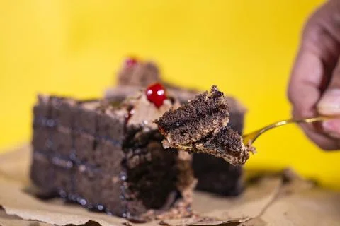Hand taking a small portion of chocolate cake from slice Stockfoto's