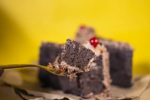 Hand taking a small portion of chocolate cake from slice Stock Photos