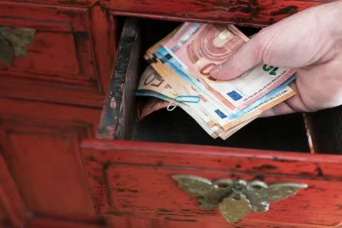 Hand taking stack of paper money from drawer 스톡 사진