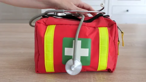 Hand is taking stethoscope and first aid kit from a table Stock Footage 221851545