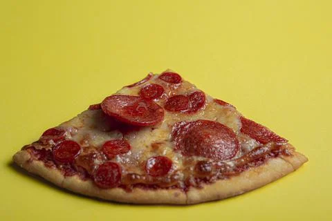 Hand taking a triangular slice of a pepperoni pizza Stock Photos