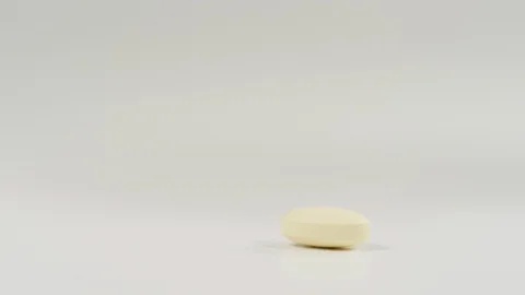 Hand taking a yellow pill Stock Footage 99750302