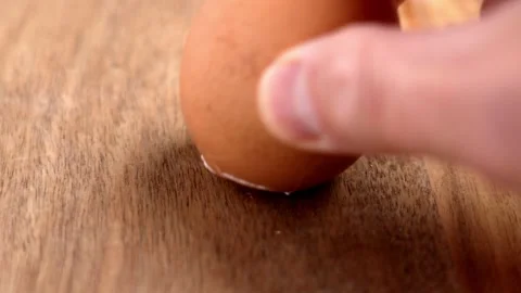 Hand tapping and cracking a brown boiled egg Stock Footage 335686282