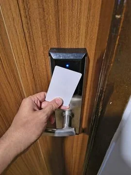 Hand tapping blank white key card on electronic smart door lock Stock Photos