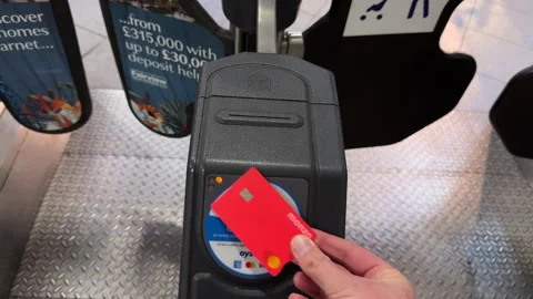 Hand tapping contactless payment card on terminal in Finsbury Park, England Stock Footage 336671340