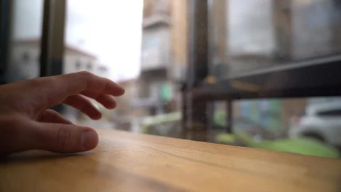 Hand tapping on a counter while waiting next to a cafe window Stock Footage 100990429