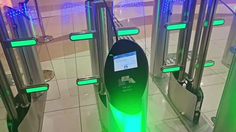 Hand tapping a Nol card on a smart metro gate reader with green lights, 스톡 동영상 333290245