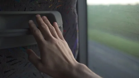 Hand taps the bus seat during a long drive out of town Stock Footage 88730939