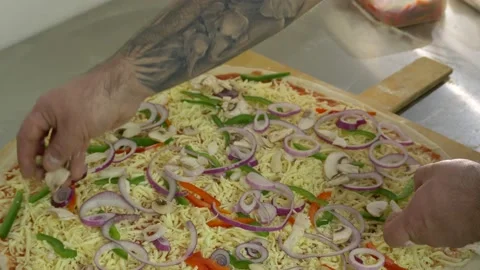 Hand of a tattooed male chef adding mushrooms to a cooking pizza 60fps 4K Stock Footage 192454635