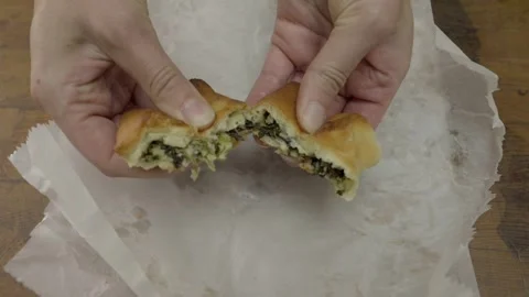 Hand tears middle eastern spinach pie in half Stock Footage 306886247