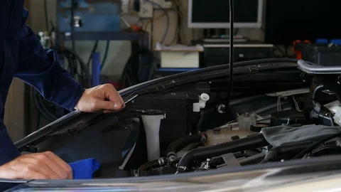 Hand of technician checking the oil level on dipstick in a car engine Stock Footage 130124222