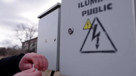 Hand of a technician opening an electrical panel with warning signs visible Stock-Footage 332893503