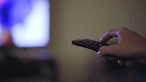 Hand with a television remote control changing the channel Stock Footage 127757453