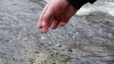 Hand testing water quality in flowing river during bright daylight hours 스톡 동영상 295338590