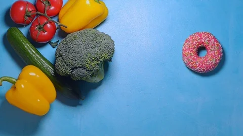 Hand in thought chooses between junk food and healthy food decides to take both Stock Footage 123782656