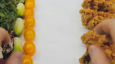 Hand in thought chooses between junk food and healthy food decides to take both Stock Footage 125653725