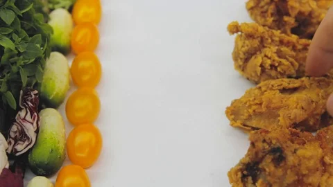 Hand in thought chooses between junk food and healthy food decides to take both Stock Footage 125653775