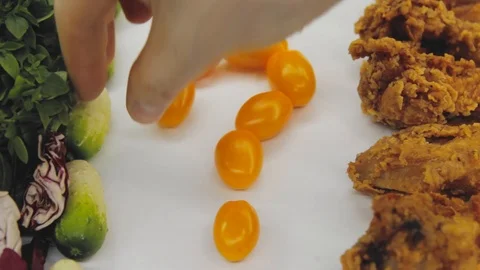 Hand in thought chooses between junk food and healthy food decides to take both Stock Footage 125653783