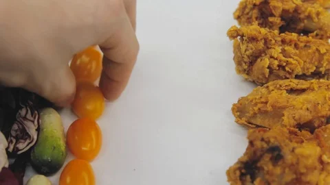 Hand in thought chooses between junk food and healthy food decides to take both Stock Footage 125653798