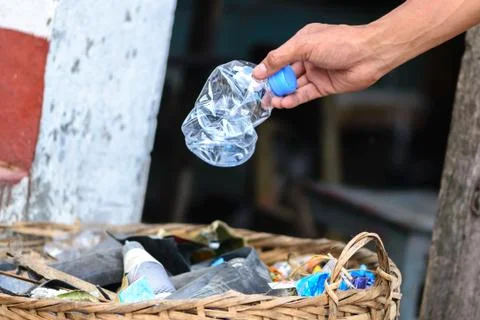 Hand throwing bottle in the basket bin. Stock Photos