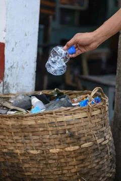 Hand throwing bottle in the basket bin. Stock Photos