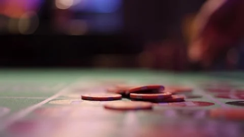 Hand throwing casino chips onto roulette betting layout. Video stock 347892985