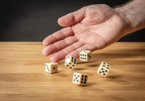 Hand throwing dice in front of a dark background 写真素材