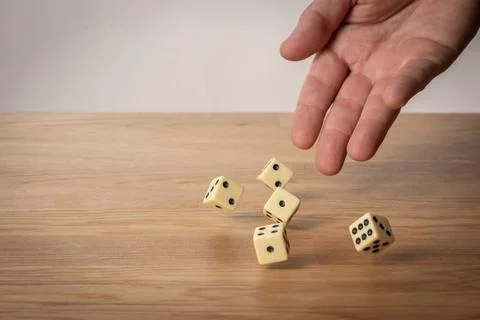Hand throwing dice in front of a dark background Foto stock