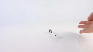 A hand throwing dice on a white background Stockbeeldmateriaal 85363279