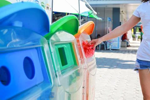 Hand throwing empty plastic bag into the trash. Fotos Stock