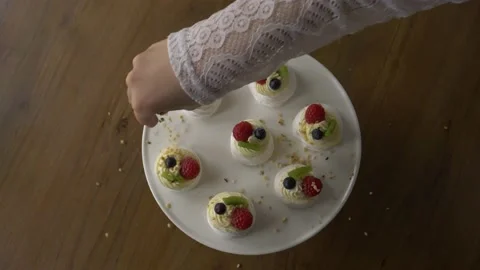 Hand throwing nuts on pavlova cake Vidéo 164917322