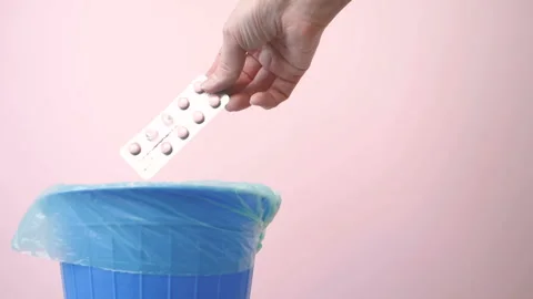 Hand throwing pills down a toilet Stock Photo - Alamy