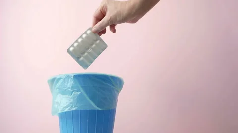 Hand throwing pills away, trash bin with pills and blisters inside, medecine  Stock Footage 163544878