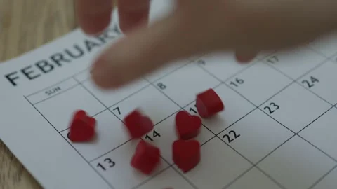 Hand throwing red heart shape bricks on calendar February 14 date valentines day Video stock 168732840