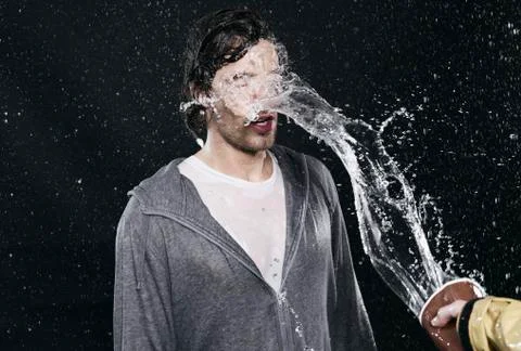 Hand throwing water on men. Stock Photos