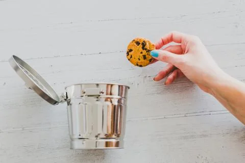 Hand throwing website cookie going into a trash can Stockfoto's