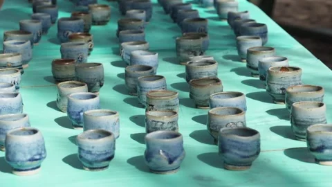 Hand thrown blue ceramic mugs sit on table during event. Stock Footage 134847975