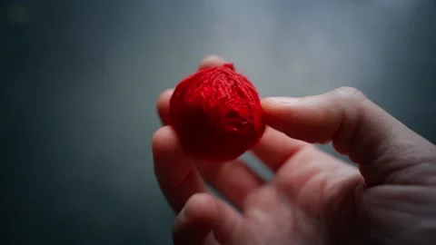 The hand throws a ball of red thread on the fingers Stock Footage 199082522
