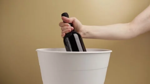Hand throws a bottle of wine into the trash bin, alcohol disposal, waste ma.. Stock Footage 269358854