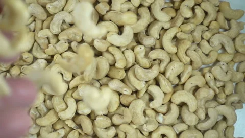 Hand throws cashew nuts in slow motion. Stock Footage 152607477