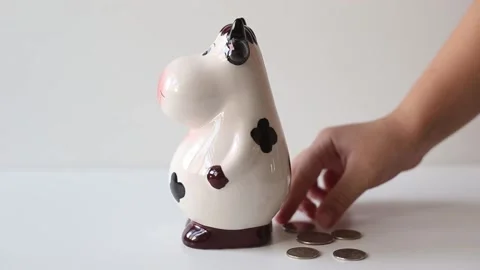 The hand throws coins into the piggy bank. Ceramic piggy bank Stock Footage