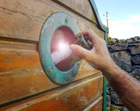 The hand throws an empty bottle in a container for broken glass. Stock Photos