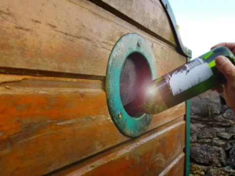 The hand throws an empty bottle in a container for broken glass. Stock Photos