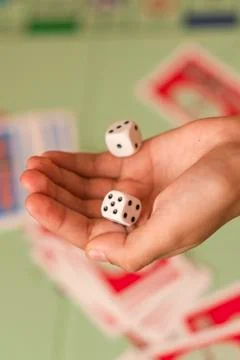 The hand throws game dice on the background of the playing field. Stock Photos