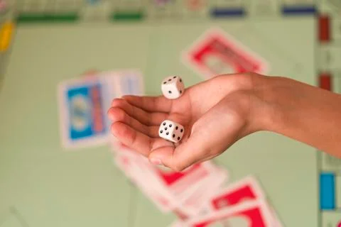 The hand throws game dice on the background of the playing field. man holds t Stock Photos