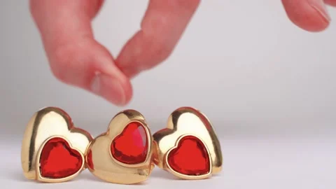 Hand throws heart shaped earring with ruby. Polyamory. Threesome. Infidelity Stock Footage 225748918