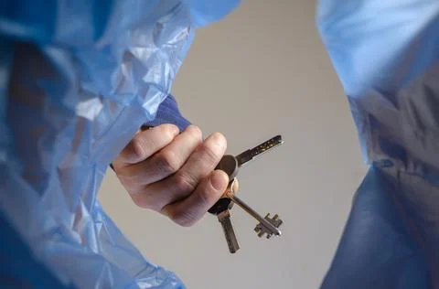 The hand throws the keys into the trash. Stock Photos