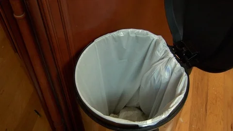 Hand throws out cucumber peels and skin into open garbage waste bin Video stock 123732680