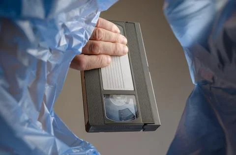 The hand throws the videotape into the trash. Stock Photos